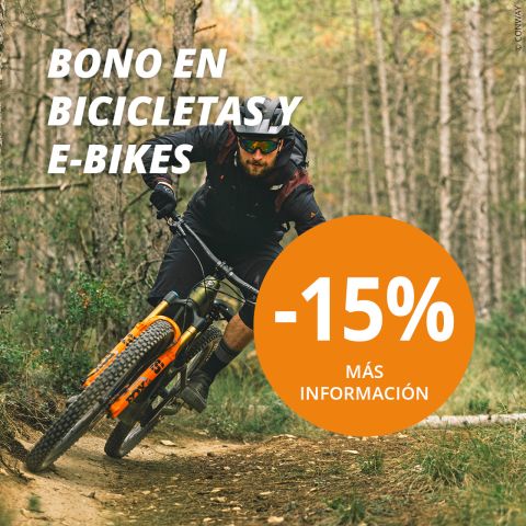 Un hombre monta en bicicleta de montaña por un sendero forestal. El texto de la imagen anuncia un 15% de descuento en bicicletas y E-Bikes con "BONO EN BICICLETAS Y E-BIKES" y "-15% MÁS INFORMACIÓN" en un círculo naranja.